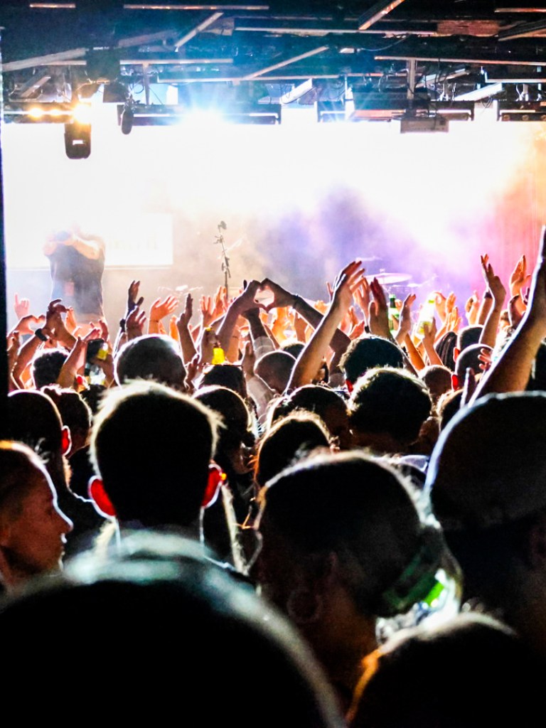 Händer i luften framför en scen