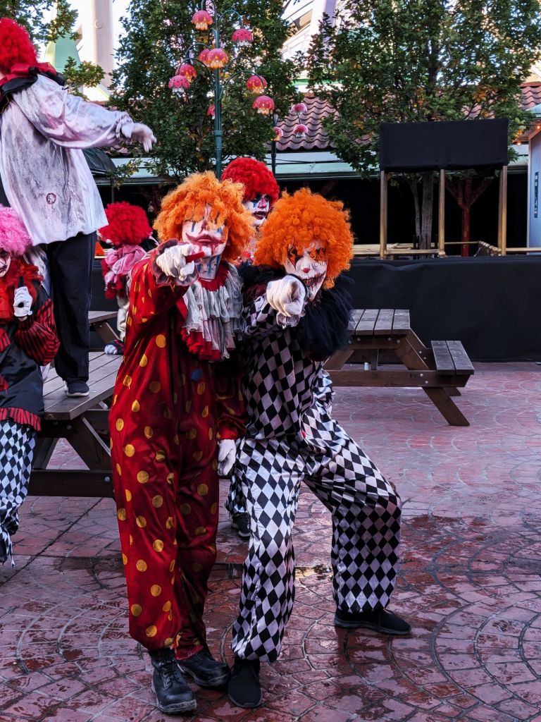 läskiga clowner på gröna lund som pekar mot fotografen