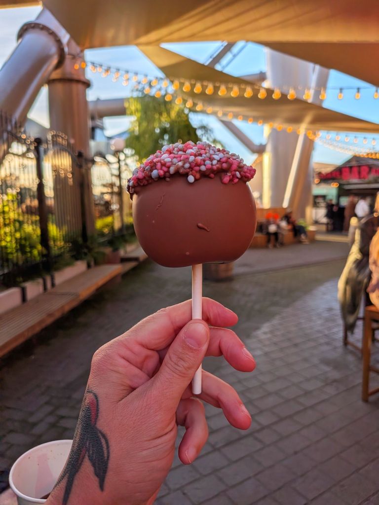 hand som håller ett kanderat äpple